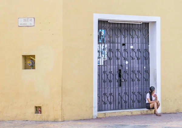 Молода жінка, сидячи на вуличку — стокове фото