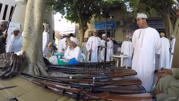 Men trading hunting rifles in a market — Stock Video