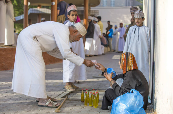 man is buying moringa oil at the market