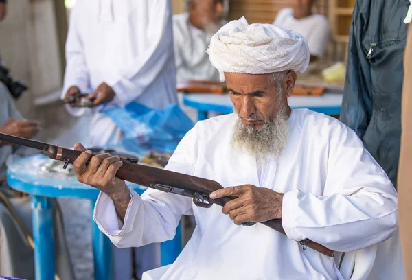 Omani uomo che vende un fucile da caccia ad un mercato — Foto Stock