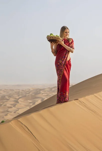 Женщина в красном платье в пустыне — стоковое фото