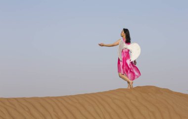 genç kadın bir çölde melek kanatlı