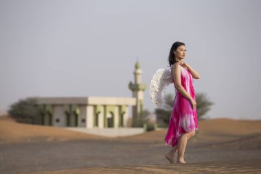 genç kadın bir çölde melek kanatlı