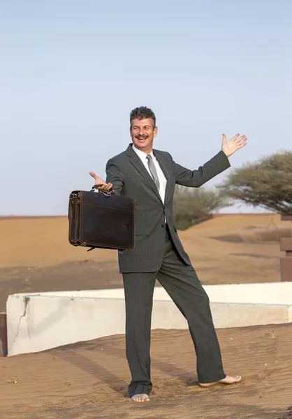 Бизнесмен с портфелем в деревне в пустыне — стоковое фото