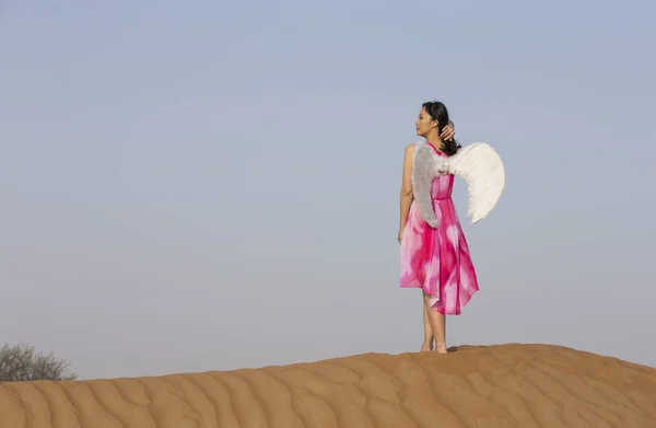 Jovem com asas de anjo em um deserto — Fotografia de Stock