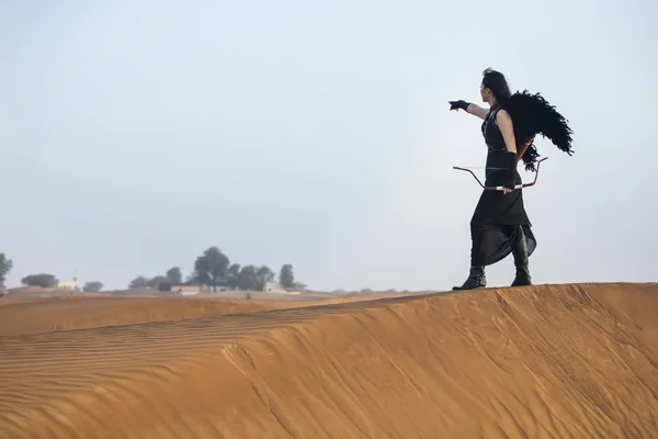 Mujer con un arco y una flecha en un desierto —  Fotos de Stock