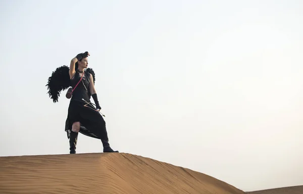 Žena s lukem a šípem v poušti — Stock fotografie