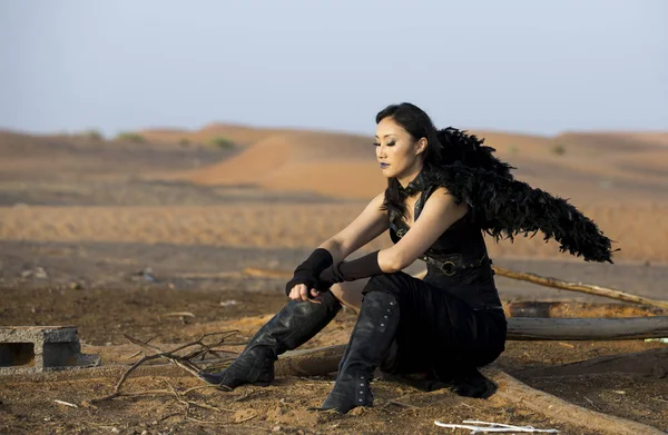 Γυναίκα που φοράει μαύρα φτερά στην έρημο — Φωτογραφία Αρχείου