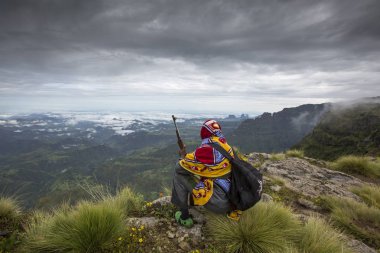 ethiopian mountain guide resting and overlooking the valley clipart