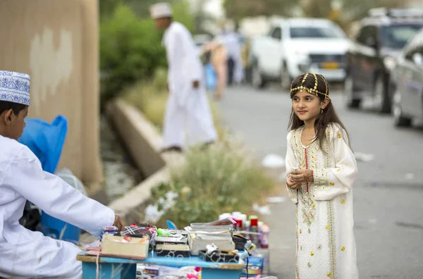 Menina em roupa tradicional Omani no mercado de brinquedos — Fotografia de Stock