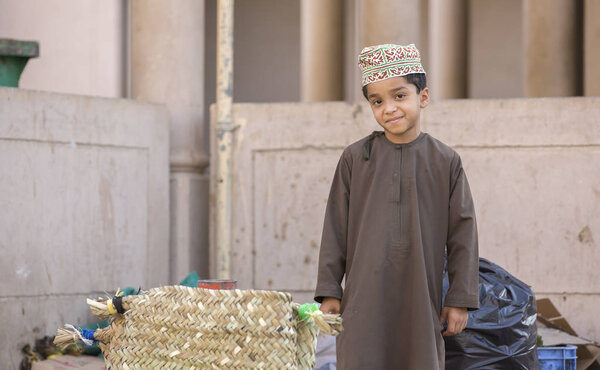 omani boy in traditional clothing at a market