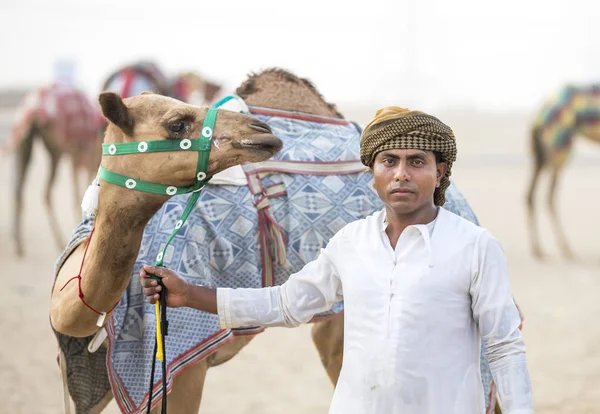 Homme avec son chameau sur une piste de chameaux dans un désert — Photo