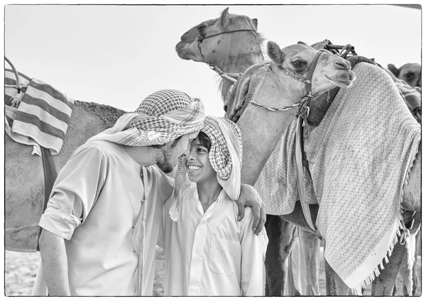 Homem e menino formação camelos — Fotografia de Stock