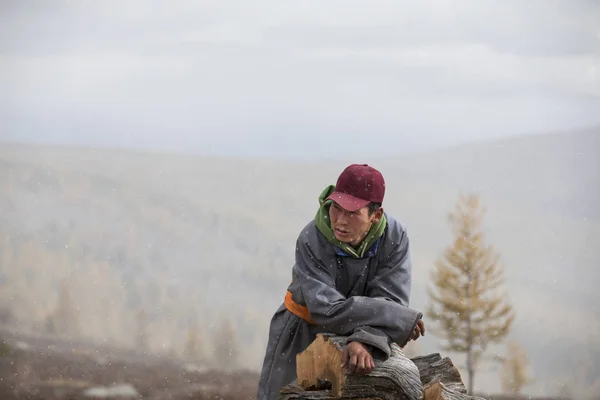 mongolian nomad relaxing on firewood