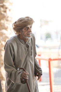 Nizwa, Oman, 10th November 2017: omani old herdsman walking across goat market clipart