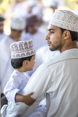 Nizwa, Umman, 10 Kasım 2017: keçi Market geleneksel giysiler içinde oğluyla omani adam
