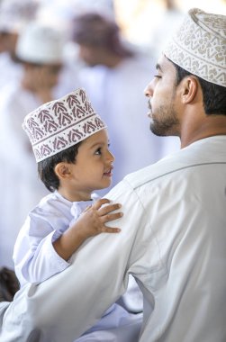 Nizwa, Umman, 10 Kasım 2017: keçi Market geleneksel giysiler içinde oğluyla omani adam
