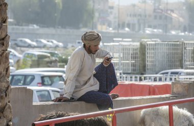 Nizwa, Oman, 10th November 2017: omani young man using smartphone clipart