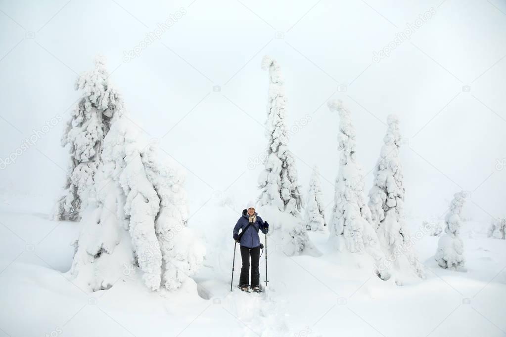 young woman in the middle of frozen trees in Riisitunturi Park in Finnish Lapland
