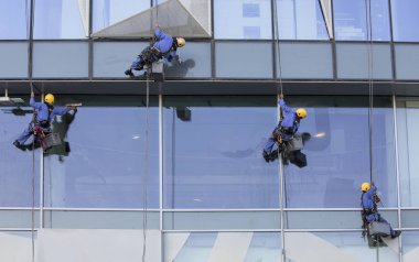 Dubai, Birleşik Arap Emirlikleri, 12 Ocak 2018: işçi pencereleri yıkamak için bir bina asılı