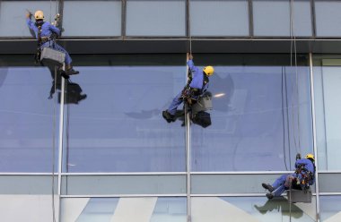 Dubai, Birleşik Arap Emirlikleri, 12 Ocak 2018: işçi pencereleri yıkamak için bir bina asılı