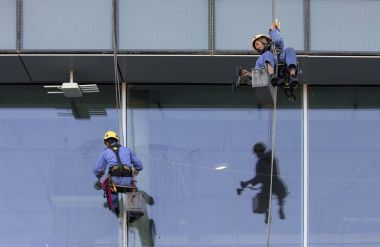 Dubai, Birleşik Arap Emirlikleri, 12 Ocak 2018: işçi pencereleri yıkamak için bir bina asılı