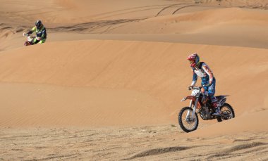 Dubai, Birleşik Arap Emirlikleri, 19 Ocak 2018: İki atlı bir çölde kir bisiklet üzerinde