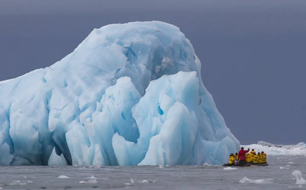 スバールバルの氷山の間の干支で旅行をする人 — ストック写真