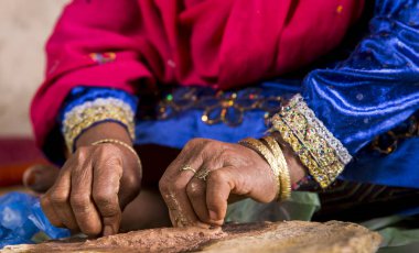 sandal ağacı taşlama bir Omai kadının elleri