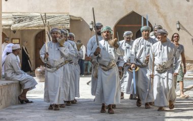 Nizwa, Umman, 2 Şubat 2018: omani erkekler geleneksel giyim şarkı ve kılıç ile dans giymek.