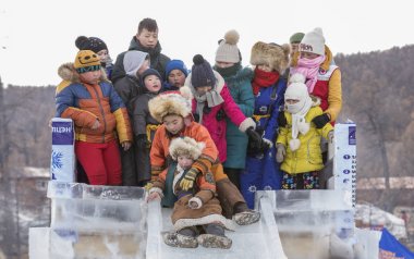 Hatgal, Moğolistan, 4 Mart 2018: Moğolca çocuk üzerinde buz bir slayt Joe geliyor donmuş bir göl Khuvsgul giymiş geleneksel giyim