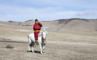 Hatgal, Moğolistan, 3 Mart 2018: Moğol adam bir bozkır Kuzey Moğolistan içinde beyaz atlı