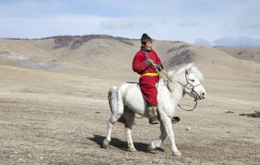 Hatgal, Moğolistan, 3 Mart 2018: Moğol adam bir bozkır Kuzey Moğolistan içinde beyaz atlı