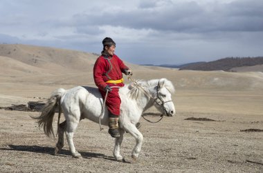 Hatgal, Moğolistan, 3 Mart 2018: Moğol adam bir bozkır Kuzey Moğolistan içinde beyaz atlı
