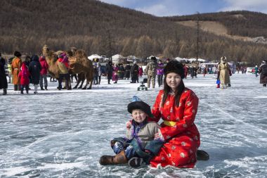 Hatgal, Mongolia, 3rd March 2018: mongolian people on a frozen lake Khuvsgul during a ice festival in winter clipart