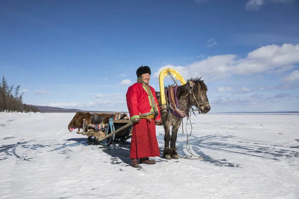 Hombre mongoliano con su trineo de caballos en el lago congelado Khovsgol — Foto de Stock