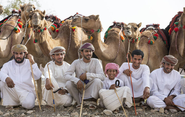 Khadal, Oman, April 7th, 2018: omani men with their camels at a countryside before a race