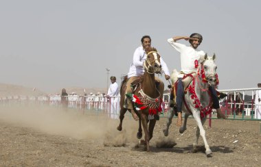 IBRI, OMAN - APRIL 28, 2018: young omani riders showing skills at traditional horse race event  clipart