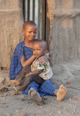 Arusha, Tanzanya, 7 Eylül 2017: Masai kızı kardeşine bakıcılık yapıyor.