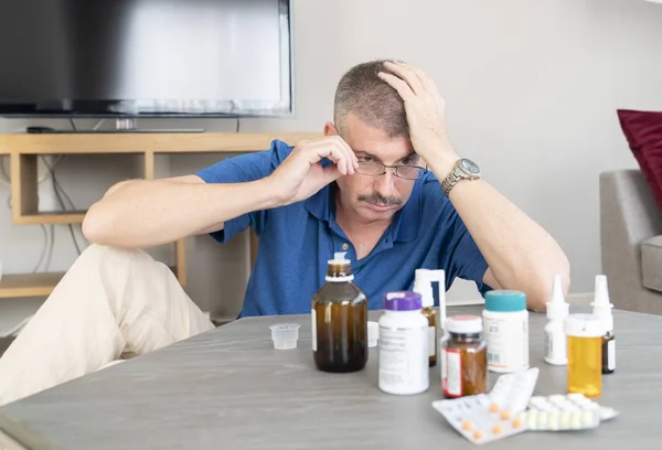 Flessen Medicijnen Tafel Met Een Man Die Zijn Hoofd Achtergrond — Stockfoto