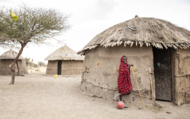 Arusha, Tanzanya, 8 Eylül 2019: Masai çocuğu evinin önünde futbol topu taşıyor.