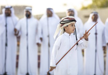 Al Ain, Birleşik Arap Emirlikleri, 16 Kasım 2019: Emirati erkekleri geleneksel giysileri içinde dans ediyorlar.