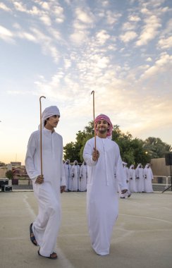 Al Ain, Birleşik Arap Emirlikleri, 16 Kasım 2019: Emirati erkekleri geleneksel giysileri içinde dans ediyorlar.