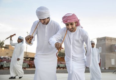 Al Ain, Birleşik Arap Emirlikleri, 16 Kasım 2019: Emirati erkekleri geleneksel giysileri içinde dans ediyorlar.