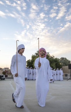 Al Ain, Birleşik Arap Emirlikleri, 16 Kasım 2019: Emirati erkekleri geleneksel giysileri içinde dans ediyorlar.