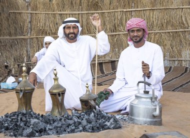 Al Ain, Birleşik Arap Emirlikleri, 16 Kasım 2019: Emirati adamları bir dalleh içinde servis edilen Qahwa adı verilen geleneksel Arap kahvesi hazırlıyorlar.