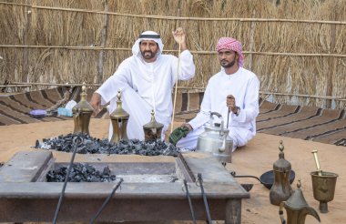 Al Ain, Birleşik Arap Emirlikleri, 16 Kasım 2019: Emirati adamları bir dalleh içinde servis edilen Qahwa adı verilen geleneksel Arap kahvesi hazırlıyorlar.