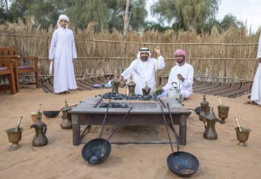 Al Ain, Birleşik Arap Emirlikleri, 16 Kasım 2019: Emirati adamları bir dalleh içinde servis edilen Qahwa adı verilen geleneksel Arap kahvesi hazırlıyorlar.