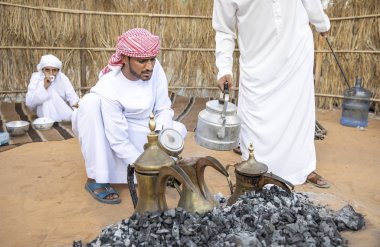 Al Ain, Birleşik Arap Emirlikleri, 16 Kasım 2019: Emirati adamları bir dalleh içinde servis edilen Qahwa adı verilen geleneksel Arap kahvesi hazırlıyorlar.
