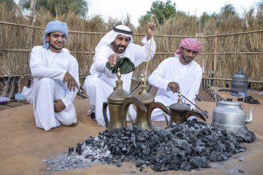 Al Ain, Birleşik Arap Emirlikleri, 16 Kasım 2019: Emirati adamları bir dalleh içinde servis edilen Qahwa adı verilen geleneksel Arap kahvesi hazırlıyorlar.